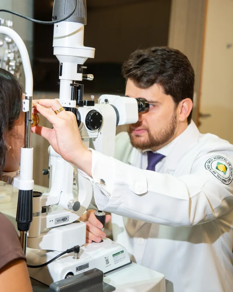 Dr. Irineu examinando um paciente na lâmpada de fenda